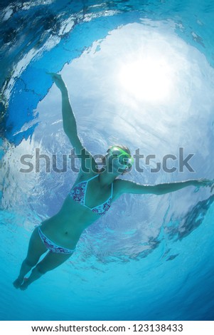 Underwater shoot of a young female athlete doing stroke in swimming pool
