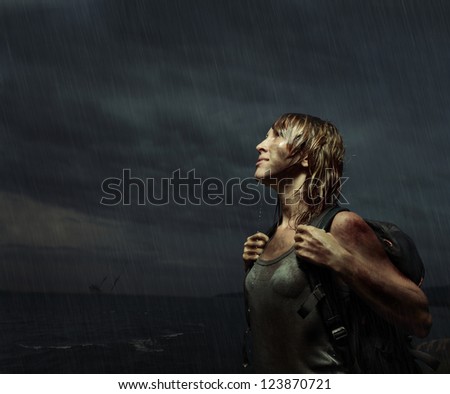 Portrait of a woman with backpack standing on the rain with wet dirty clothes and wet hair with bloody bruises on arm