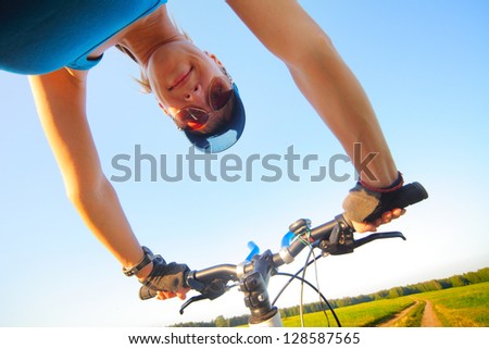 Young lady with bicycle at summer sunny day