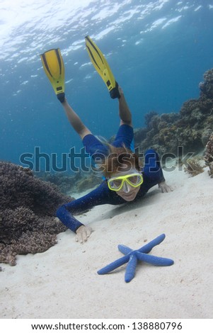 Young lady diving on a breath hold and exploring sea bottom