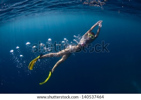 Young lady finning underwater on a breath hold
