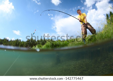 Young man fishing on a green pond\'s coast with underwater view of weed on a bottom