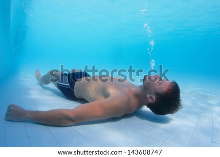 Young man making bubbles in a pool