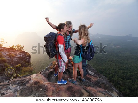 Group of happy hikers standing on top of a mountain