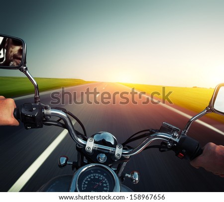 Driver riding motorcycle on an empty asphalt road