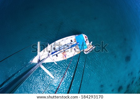 Young couple relaxing on board of the sail boat anchored in shallow tropical bay