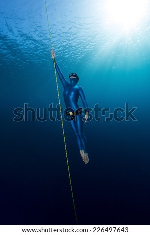 Lady free diver ascending from depth without fins. Free immersion discipline