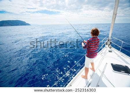 Young man fishing in the sea from sail boat