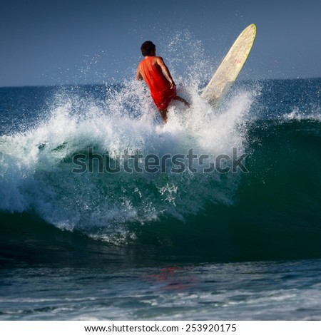 Surfer riding on the wave with long board. Midigama beach, Sri Lanka