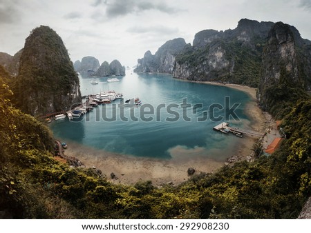 View to the calm lagoon with pier and boats situated in Ha Long Bay, Vietnam