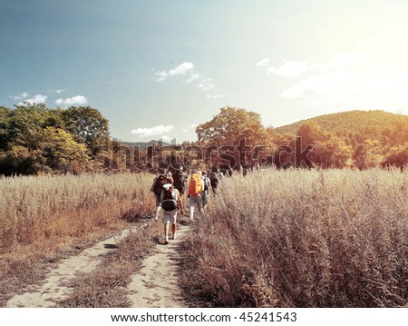 Group of backpackers walking on rural road