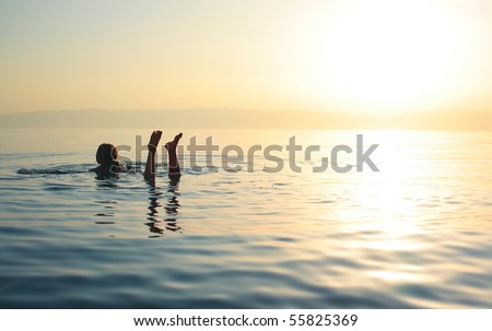 Woman swimming in salty water of a Dead Sea