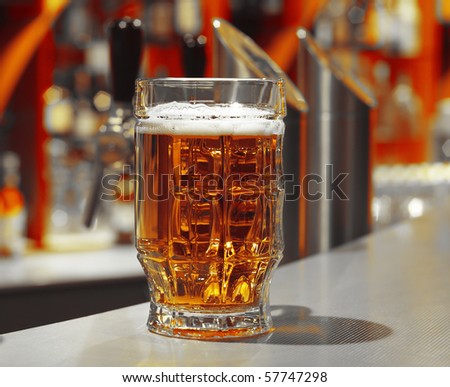 Glass with beer on table in a pub