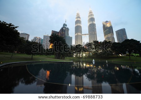 KUALA LUMPUR - JANUARY 22: Petronas Twin Towers - tallest twin buildings in the world at the evening light with reflection in a pond January 22, Kuala Lumpur, Malaysia