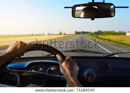 Drivers\'s hands on a steering wheel of a car