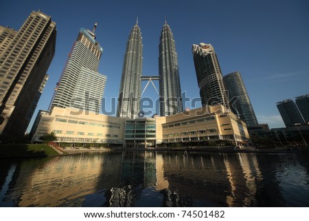 KUALA LUMPUR - FEBRUARY 17: Petronas Twin Towers - tallest twin buildings in the world at the sunrise light with reflection in a pond in Kuala Lumpur on On Februrary 17, 2011. The building is 451,9 m and 88 floors.