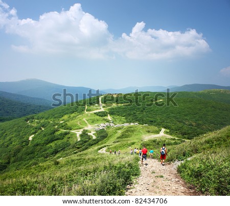 Group of tourists walking on countryside roads in mountains