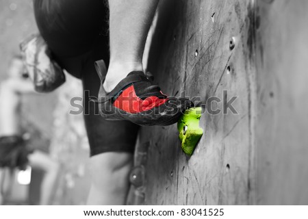 Young man\'s foot climbing indoor wall