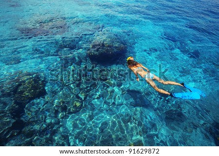 Young woman swimming in a clear tropical sea