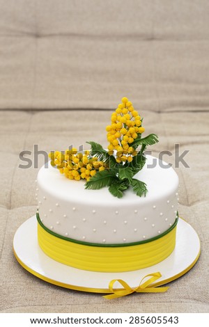 white cake with sugar mimosa covered with mastic