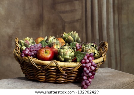 Basket of fruit including apples, grapes and avocados as a still life