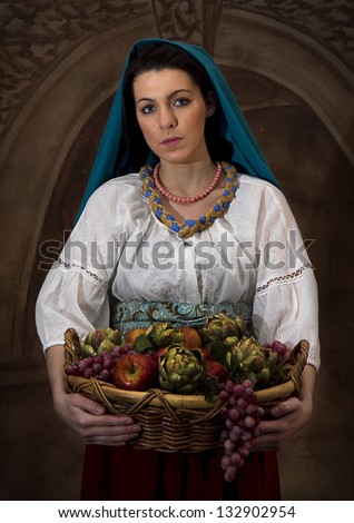 Image of model dressed in old world clothing carrying a basket of fruit - recreating old paintings of years gone by but with photography