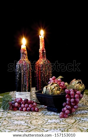 Romantic table with candles dripping with melted wax and grapes - old world still life