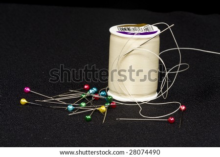 Spool of thread,needle and beaded top sewing pins