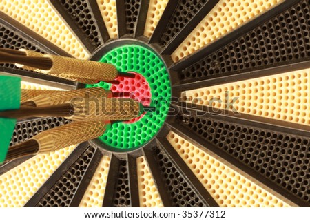 Six darts in bulls eye on dart board