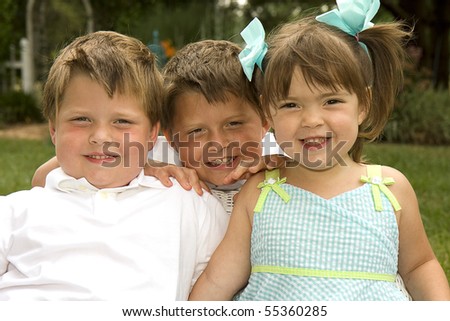 Brothers and their sister enjoying each other\'s company outdoors