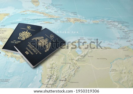 Passports of two Caribbean states, Saint Kitts and Nevis and Dominica on a map of the Caribbean Sea
