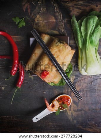 Fried spring rolls with  shrimps, bok choi, chili pepper, hot sauce on a vintage ceramic plate