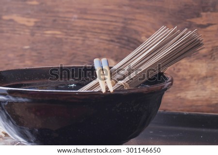 Japanese Soba noodles on a vintage wooden background with the chop sticks