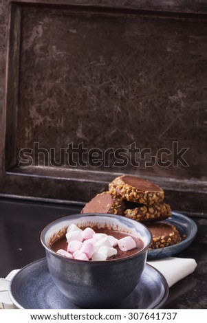 Home made hot chocolate, served on a vintage metal tray with chocolate cookies and marshmallows