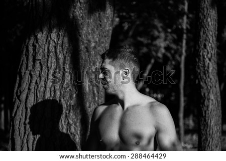 Man photographed in street workout session. Just finished one of his exercises.Photo was taken in early morning, around 6am in city park Dudova forest. Black and white photo.