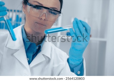 Similar – Image, Stock Photo Focused scientist examining chemical solution in laboratory