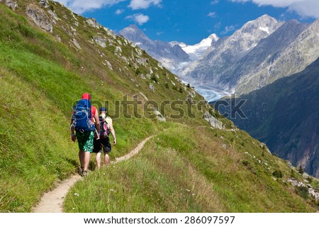 group of friends in hiking in high mountains. sky background with blue clouds