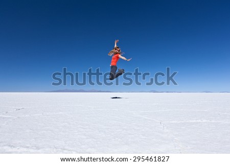 Woman jumping in the sky on Bolivia salar de Uyuni