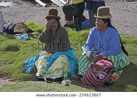 Titicaca lake, Bolivia - January 2: Bolivian women chew coca while waiting for  ferry Copacabana, Bolivia on January 2,2009. Chewing coca is legal in Bolivia.