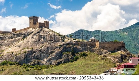 Landscape of Crimea, scenic view of old Genoese fortress in Sudak, Russia. It is landmark of Crimea. Panorama of medieval ruins at mountain top over Black Sea. Concept of summer travel in Crimea. 商業照片 © 