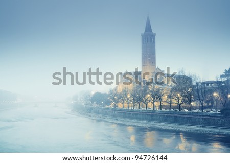 Sant\'Anastasia church and Adige River at a foggy winter evening. Verona - Italy