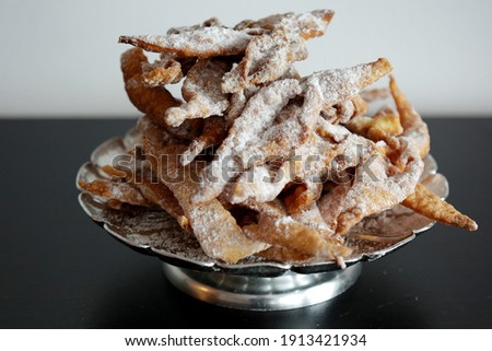 Faworki (angel wings), sprinkled with powdered sugar, brushwood, kerchief, chrissy, crepe.Traditional, Polish carnival delicacy. Crisp cake with a sweet taste, in the shape of a complex bow.