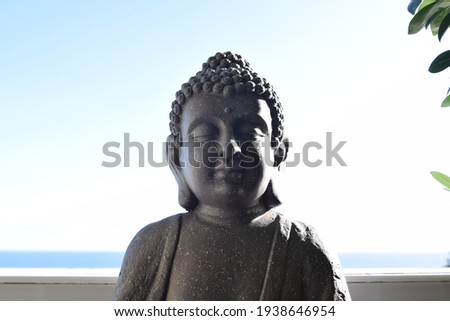 A gray Buddha statue with the Mediterranean sea in the background Foto d'archivio © 