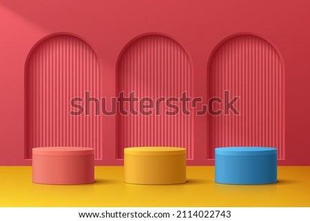 Abstract 3D room with realistic blue, yellow and red cylinder pedestal podium set on red arch door. Minimal scene for product display presentation. Vector geometric platform design. Stage for showcase 商業照片 © 