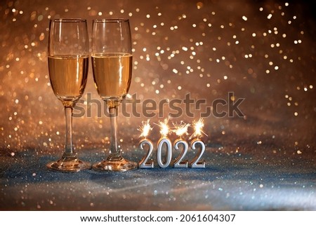 2022 New Year. Happy new year 2022 greeting card. Champagne glasses on glitter background