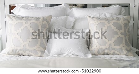 fancy pillows on the bed with mirror in the headboard