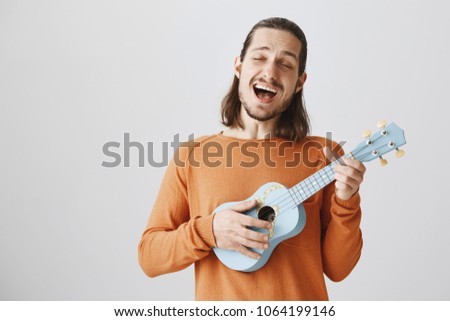 Similar – Image, Stock Photo Cheerful man playing ukulele guitar