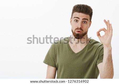 Portrait of impressed guy checking out awesome idea of friend saying wow and not bad showing okay gesture raising eyebrows as being amazed with nice plan posing astonished over white background Сток-фото © 