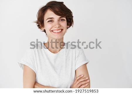 Close-up of happy professional girl cross arms on chest, smiling at camera, white background. Copy space