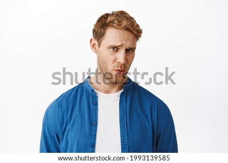Ouch that hurts. Handsome redhad man cringe and frown, look at something uncomfortable or embarrassing, compassion pity for someone in pain, standing over white background Foto stock © 
